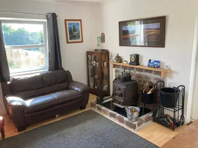 a living room with a leather couch and a fireplace at Little Haven in Launceston