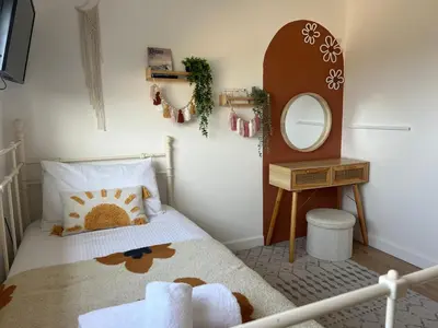 a small bedroom with a bed and a mirror at Family Home with Sauna & Garden in Newquay