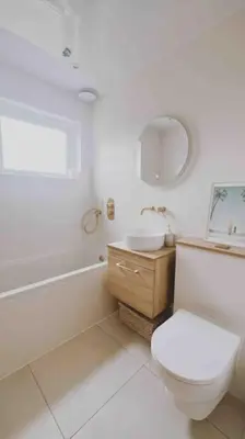 a white bathroom with a toilet and a sink at Family Home with Sauna & Garden in Newquay