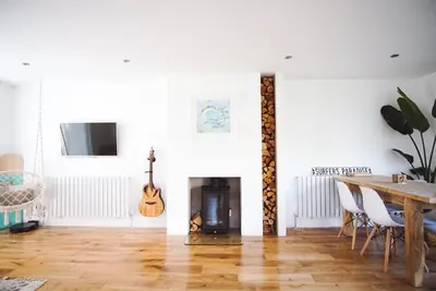 a living room with a table and a fireplace at Family Home with Sauna & Garden in Newquay