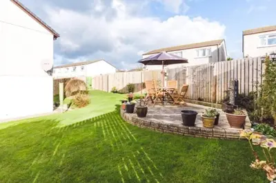 a garden with a patio and an umbrella at Family Home with Sauna & Garden in Newquay