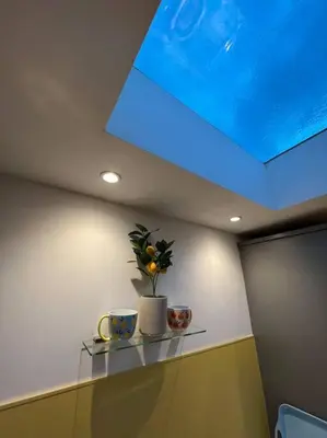 a room with a skylight and two cups on a shelf at Citrus Chalet, modern light and airy! in Redruth