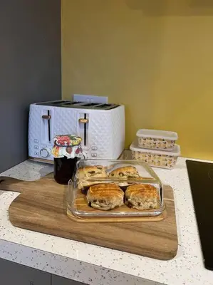 a tray of pastries on a counter next to a toaster at Citrus Chalet, modern light and airy! in Redruth