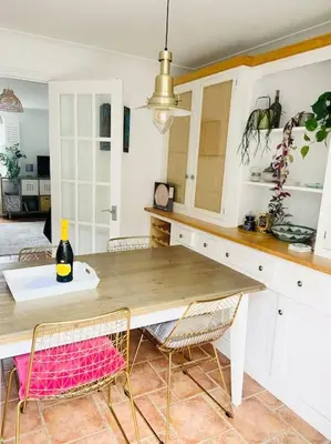 a kitchen with a wooden table and chairs at Charlestown Cottage Harbour & Beach short walk! in Charlestown
