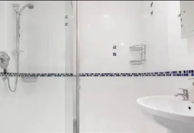 a bathroom with a glass shower and a sink at Charlestown Cottage Harbour & Beach short walk! in Charlestown