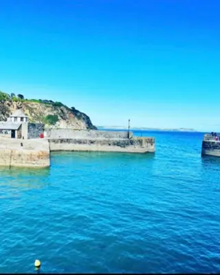 a large body of blue water with a hill in the background at Captains Quarters in Charlestown