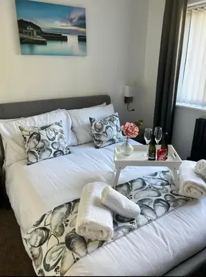 a bedroom with two beds and a table with towels at Captains Quarters in Charlestown