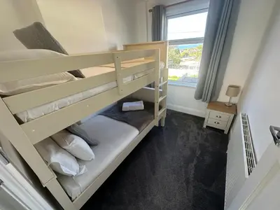 a bunk bed in a room with a window at Porth View Newquay in Saint Columb Minor