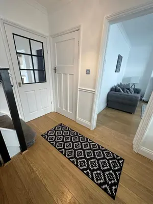 a living room with a door and a rug at Porth View Newquay in Saint Columb Minor