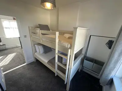a room with two bunk beds with a mirror at Porth View Newquay in Saint Columb Minor