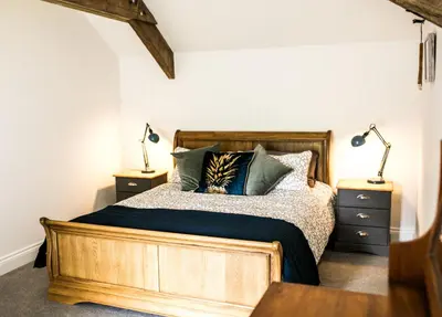 a bedroom with a wooden bed with two lamps at Glynn Bull Pen in Bodmin