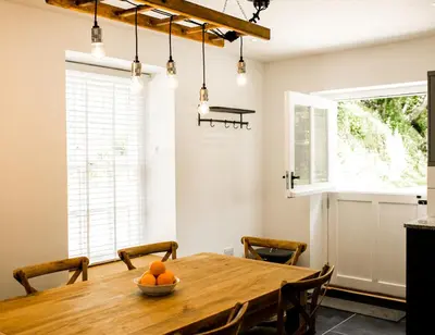 a dining room with a wooden table and chairs at Glynn Bull Pen in Bodmin