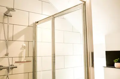 a shower with a glass door in a bathroom at Glynn Bull Pen in Bodmin
