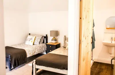 a bedroom with two beds and a sink at Glynn Bull Pen in Bodmin