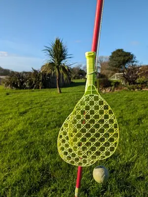 a tennis racket and a ball on a field at Clotted Cream -Lydcott Glamping, Cornish Sea Views in Looe