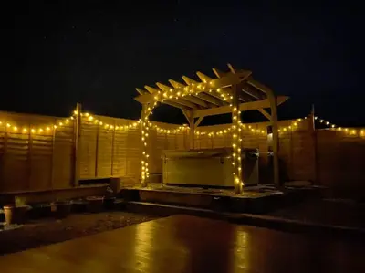 a pergola with lights on it at night at Secluded Luxury Pod with Hot Tub in Launceston