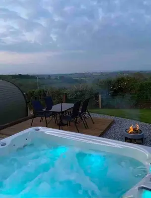 a swimming pool with a table and chairs and a table and a table at Secluded Luxury Pod with Hot Tub in Launceston