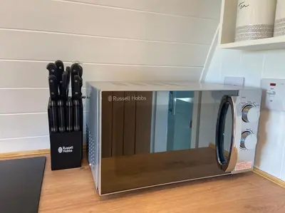 a microwave sitting on the floor with a bunch of knives at Secluded Luxury Pod with Hot Tub in Launceston