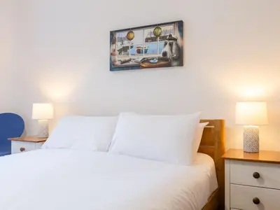 a bedroom with a white bed and two lamps at Holiday Home Marshmallow House by Interhome in St Austell