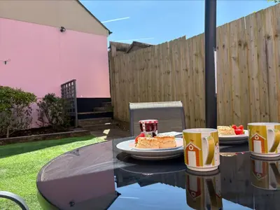a table with a plate of food and two cups on it at Holiday Home Marshmallow House by Interhome in St Austell