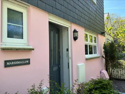 a pink house with a black door at Holiday Home Marshmallow House by Interhome in St Austell
