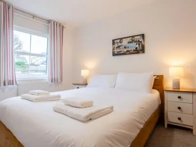 a bedroom with a white bed with towels on it at Holiday Home Marshmallow House by Interhome in St Austell