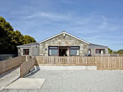 a house with a wooden fence in front of it at Holiday Home Francis Bungalow by Interhome in Helston