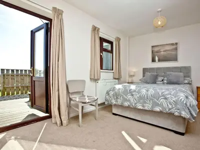 a bedroom with a bed and a table and a chair at Holiday Home Francis Bungalow by Interhome in Helston