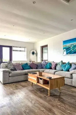 a living room with a large couch and a coffee table at Holiday Home Francis Bungalow by Interhome in Helston