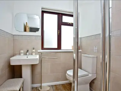a bathroom with a toilet and a sink and a window at Holiday Home Francis Bungalow by Interhome in Helston