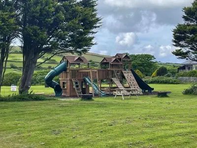 a playground with a slide in a park at Chalet Hot Tub Lodge 1 by Interhome in Helston