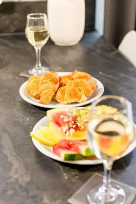 two plates of food on a table with glasses of wine at Chalet Hot Tub Lodge 1 by Interhome in Helston