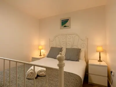 a bedroom with a white bed and two lamps at Chalet Lodge 2 by Interhome in Helston