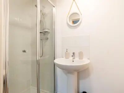 a white bathroom with a sink and a shower at Chalet Lodge 2 by Interhome in Helston