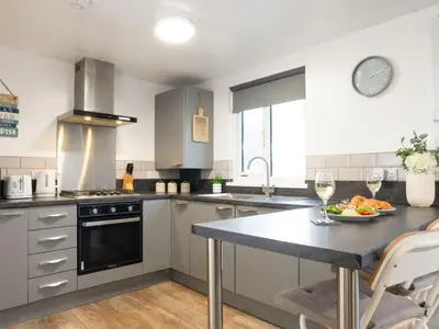 a kitchen with a table with a plate of food on it at Chalet Lodge 2 by Interhome in Helston