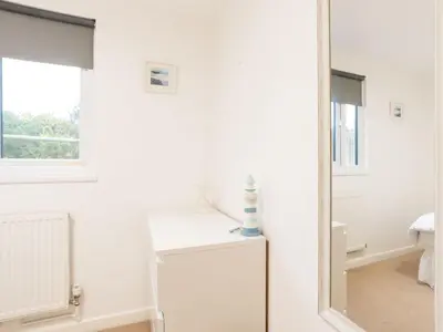 a white bathroom with a mirror and a sink at Chalet Hot Tub Lodge 2 by Interhome in Helston