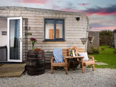 a tiny house with a table and chairs and a barrel at Chalet Hot Tub Lodge 2 by Interhome in Helston