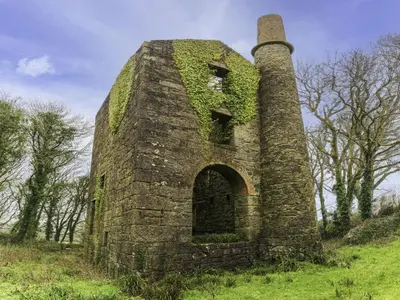 an old brick building with ivy growing on it at Chalet Hot Tub Lodge 3 by Interhome in Helston