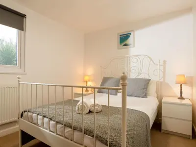 a bedroom with a white bed and a window at Chalet Lodge 3 by Interhome in Helston