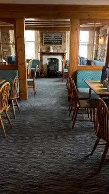 a dining room with tables and chairs and a fireplace at The Badger Inn in Carbis Bay