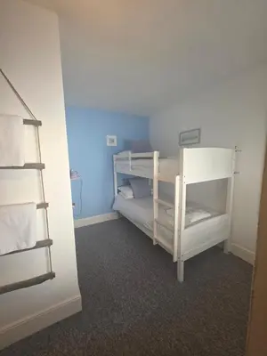 a bedroom with two bunk beds and a ladder at The Badger Inn in Carbis Bay