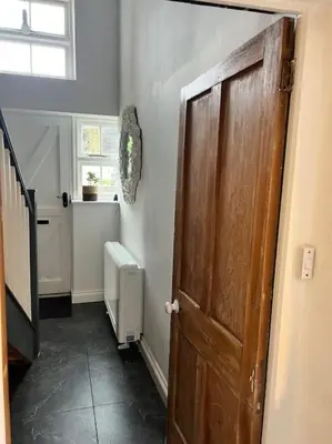 a hallway with a wooden door in a room at Little Hillside in Porthtowan