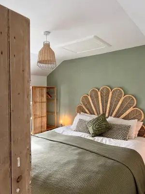 a bedroom with a large bed with a wooden headboard at Little Hillside in Porthtowan