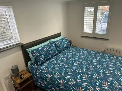 a bedroom with a bed with a blue comforter at HeyRic in Padstow