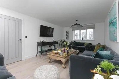 a living room with a blue couch and a table at Abelia in St Ives