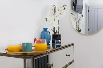 a table with two glasses of orange juice and a mirror at Abelia in St Ives