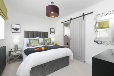 a bedroom with a large bed with white walls at Abelia in St Ives