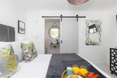 a bedroom with a bed with a tray of fruit on it at Abelia in St Ives