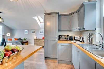 a kitchen with white cabinets and a bowl of fruit on a counter at 1 Bed in Fowey oc-p00802 in Fowey