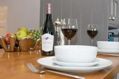 a table with a bottle of wine and two glasses at 1 Bed in Fowey oc-p00802 in Fowey